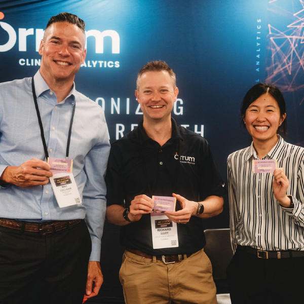 three people holding up card smiling at camera