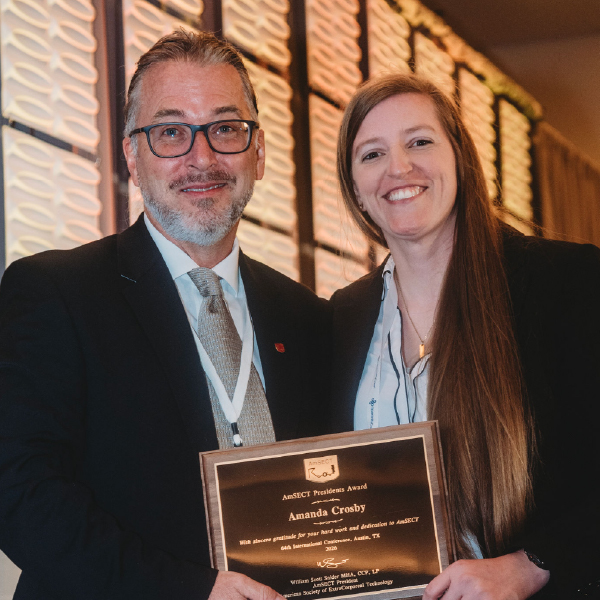 two people holding award smiling at camera
