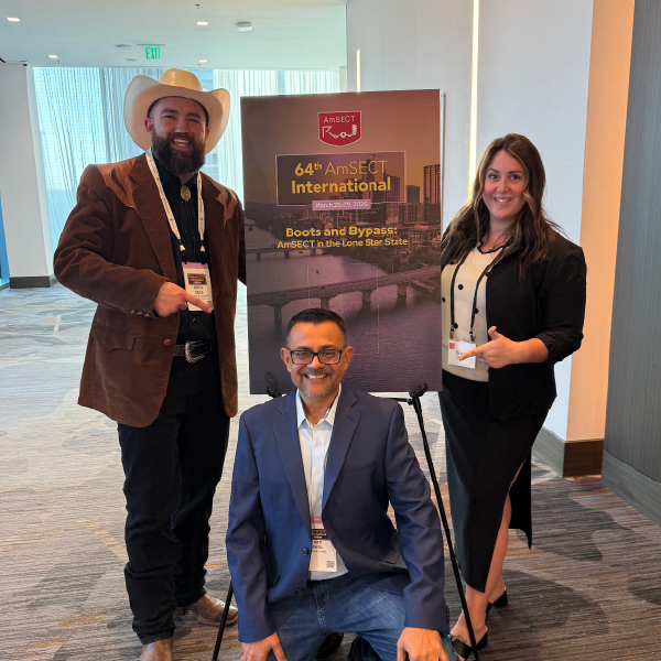 three people next to 64th amsect international conference sign