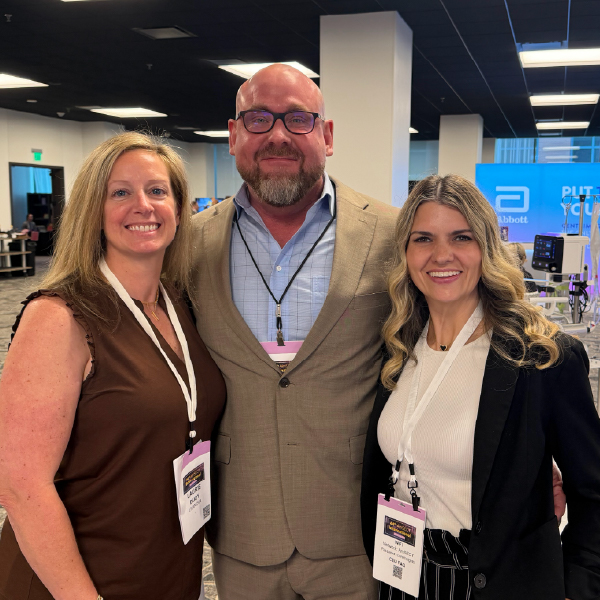 three people standing next to each other smiling at camera